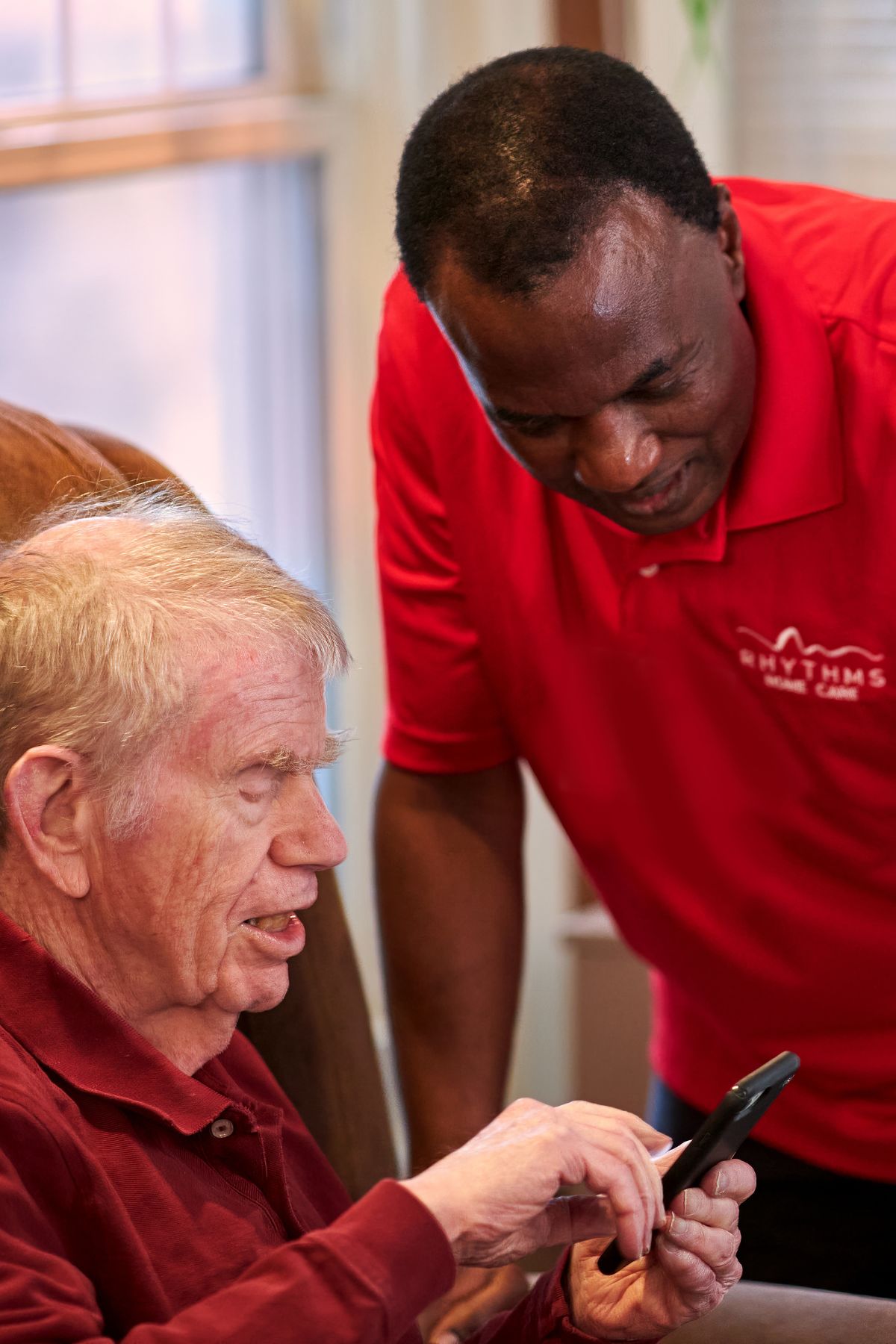 caregiver helping client with his phone portrait