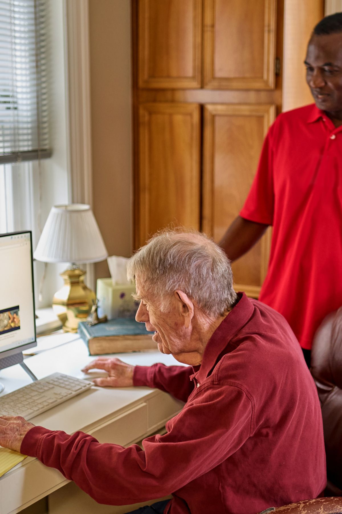 caregiver helping client at his computer portrait