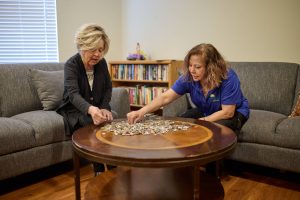 caregiver and resident putting a puzzle together