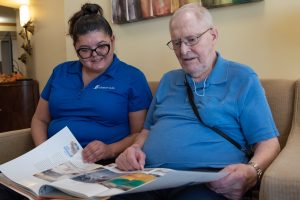 caregiver and resident reading a book