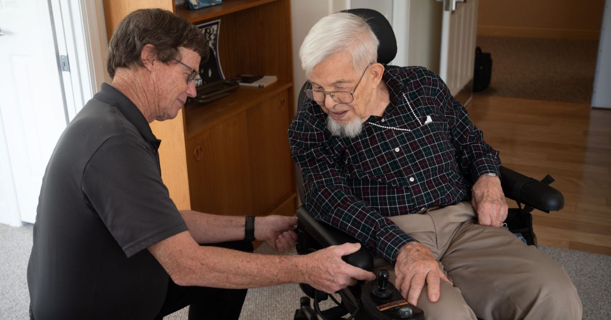 caregiver assisting a resident with his motorized wheelchair