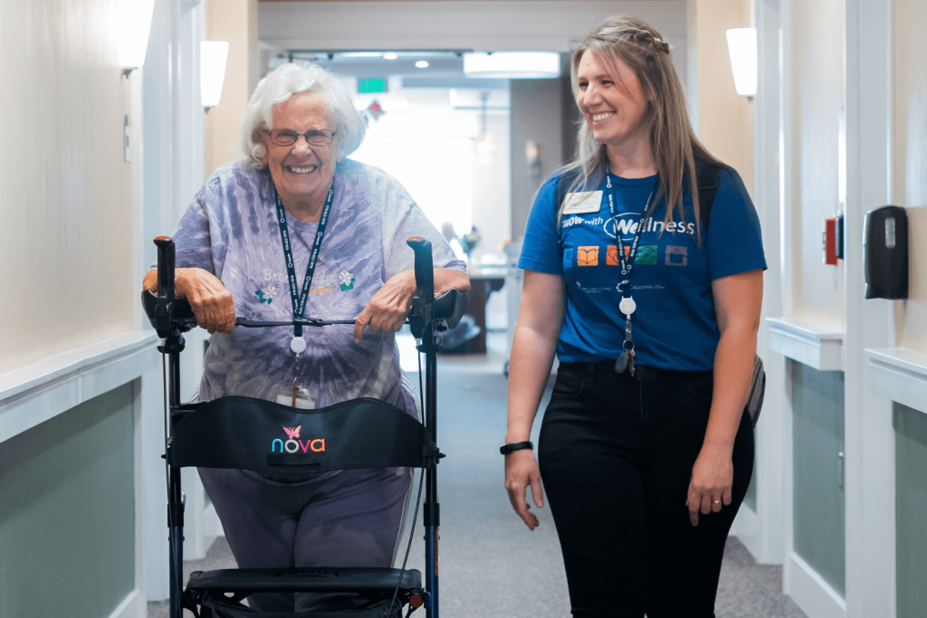 Resident and team member walking down hallway Resident and team member walking down hallway