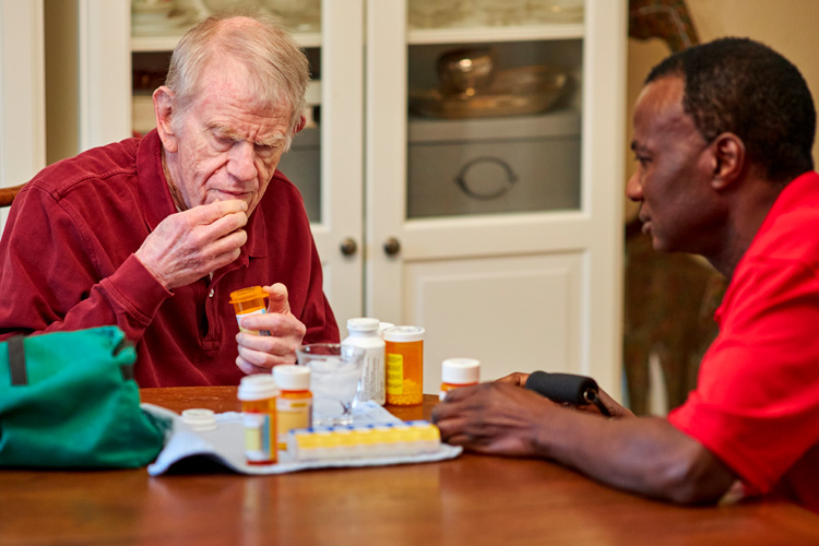 rhythms home care senior man and caregiver with medications